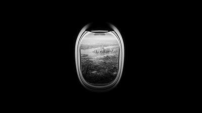 A black-and-white view of South Brooklyn and Lower Manhattan through an aeroplane window.