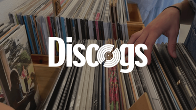 The Discogs logo over a photograph of someone browsing rows of vinyl records.