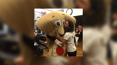 Jack hugging a man in a smiling pizza-slice costume.